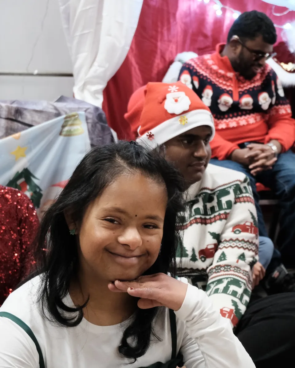 A girl smiling at the camera at the TSC Christmas party.